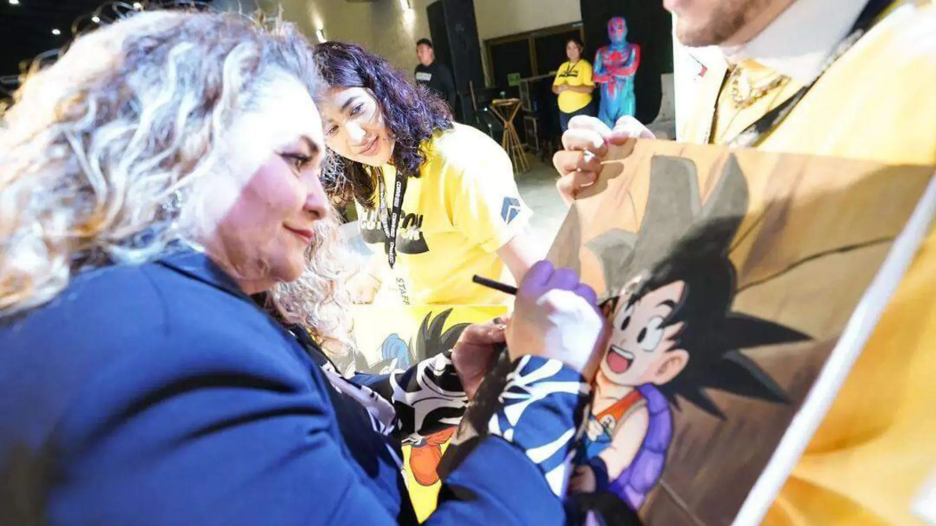 Laura Torres firmando un cuadro de Goku